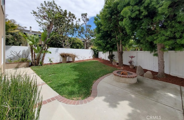 view of yard featuring a fenced backyard, a fire pit, and a patio area