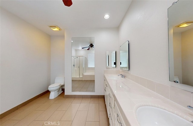 full bathroom with double vanity, toilet, ceiling fan, an enclosed shower, and a sink