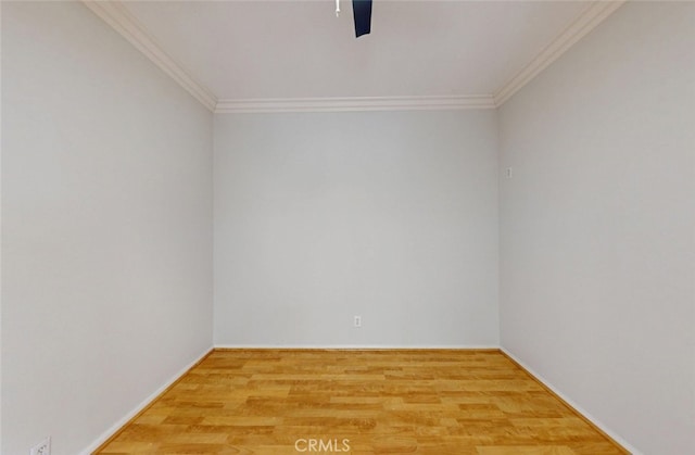 spare room featuring baseboards, a ceiling fan, wood finished floors, and ornamental molding