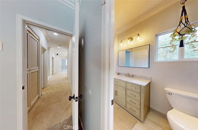 half bath featuring crown molding, toilet, baseboards, and vanity