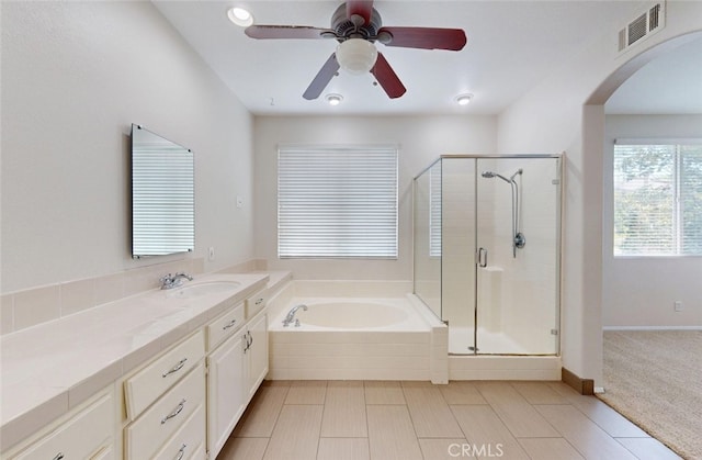 bathroom featuring a ceiling fan, a shower stall, a garden tub, and visible vents