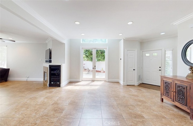 unfurnished living room with wine cooler, ornamental molding, french doors, and recessed lighting