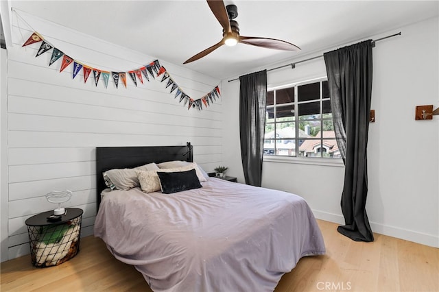 bedroom featuring baseboards, a ceiling fan, and wood finished floors