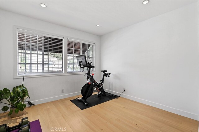 workout room featuring baseboards, recessed lighting, and wood finished floors