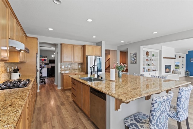 32701 Juniper Berry Dr, Winchester, CA 92596 - kitchen featuring stainless steel appliances, a sink, wood finished floors, a center island with sink, and under cabinet range hood