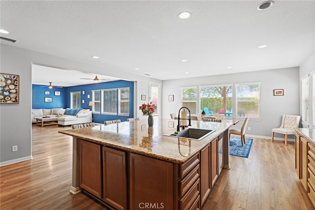 32701 Juniper Berry Dr, Winchester, CA 92596 - kitchen with a sink, wood finished floors, light stone countertops, baseboards, and recessed lighting