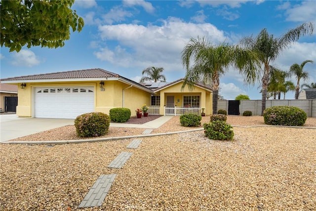 ranch-style house featuring driveway, solar panels, fence private yard, and stucco siding