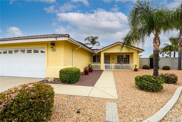 ranch-style house featuring fence, a garage, stucco siding, concrete driveway, and solar panels