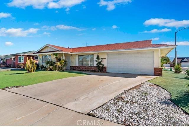 single story home with a garage, driveway, a front lawn, and brick siding