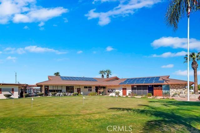 back of house with roof mounted solar panels