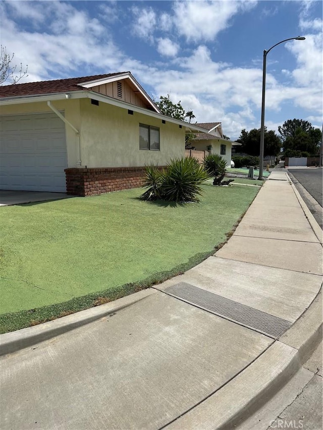 580 Mount Hood Dr, Hemet, CA 92543 - view of property exterior with a garage, stucco siding, and a lawn