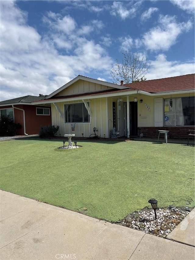 580 Mount Hood Dr, Hemet, CA 92543 - view of front facade featuring a front lawn, brick siding, and board and batten siding