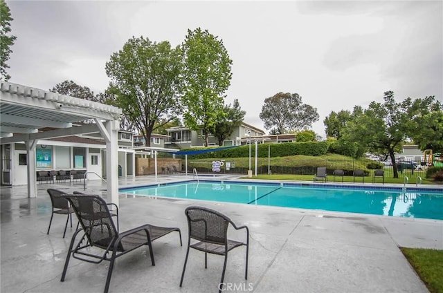 community pool featuring a patio area, fence, and a pergola