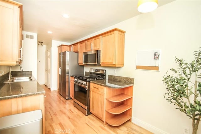 kitchen featuring visible vents, open shelves, a sink, stainless steel appliances, and light wood-style flooring