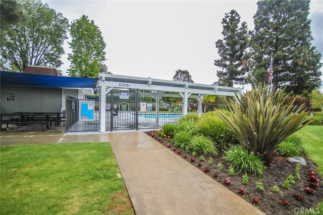 view of home's community featuring fence, a pool, and a yard