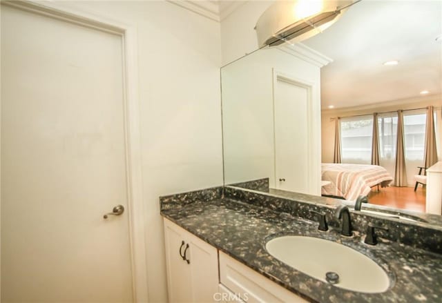 bathroom featuring crown molding, recessed lighting, and vanity