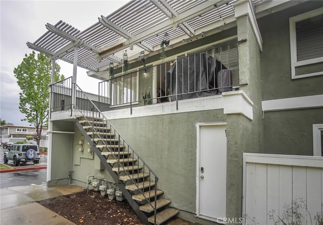 exterior space with stucco siding and a pergola
