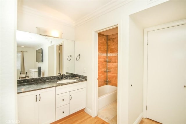 bathroom featuring vanity, ornamental molding, baseboards, and wood finished floors