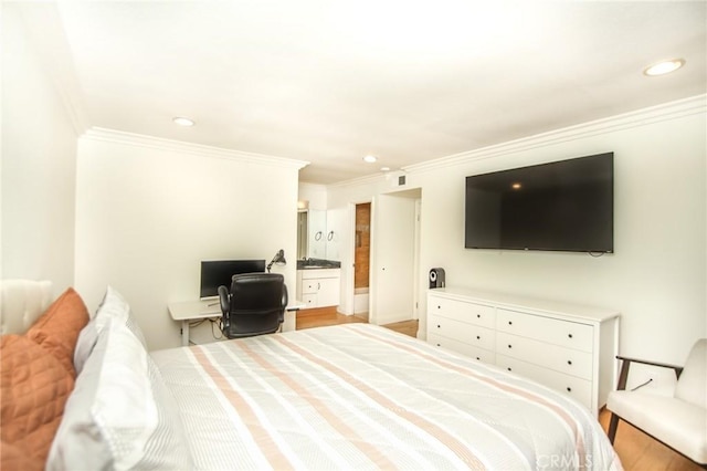 bedroom featuring ornamental molding, recessed lighting, wood finished floors, and connected bathroom