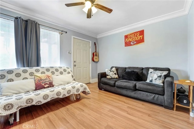 living room featuring crown molding, a ceiling fan, baseboards, and wood finished floors
