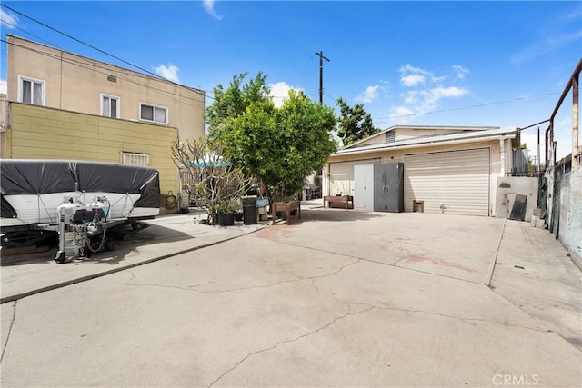 exterior space featuring a detached garage, fence, and an outdoor structure