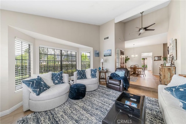 living room featuring visible vents, baseboards, ceiling fan, and wood finished floors