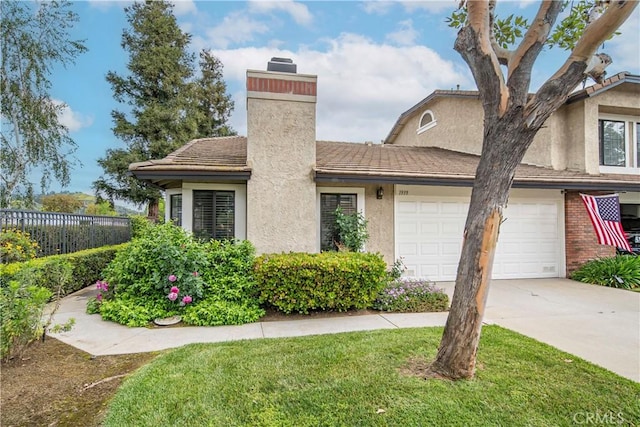 view of front of property with a chimney, a front yard, a garage, fence, and concrete driveway