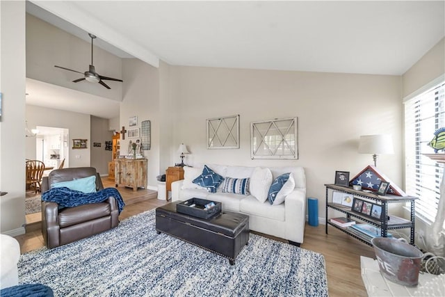 living area with baseboards, ceiling fan, wood finished floors, and lofted ceiling