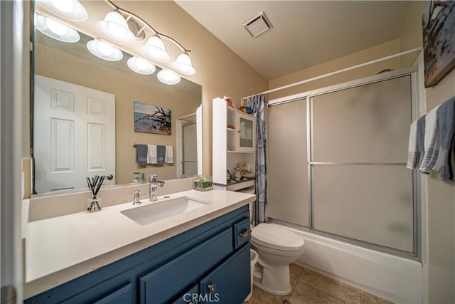 bathroom with vanity, toilet, tile patterned floors, combined bath / shower with glass door, and visible vents
