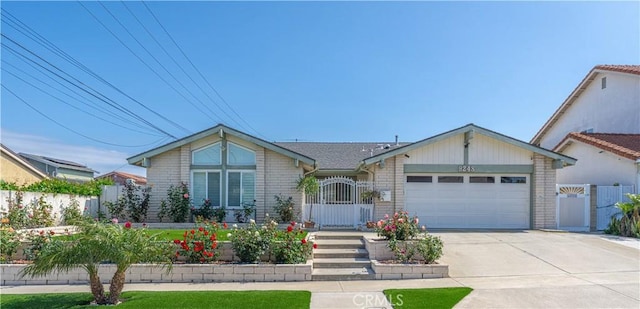 view of front of house featuring a garage, concrete driveway, brick siding, fence, and a gate