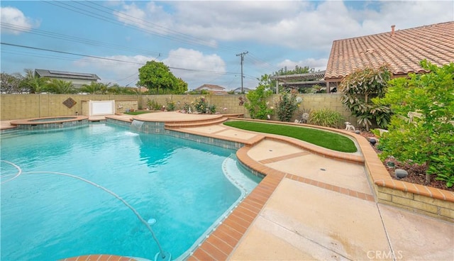 view of swimming pool featuring a fenced backyard, a pool with connected hot tub, and a patio