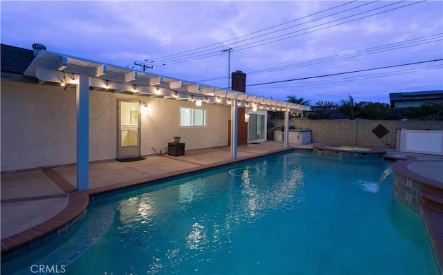 view of swimming pool featuring a patio, a pool with connected hot tub, and fence