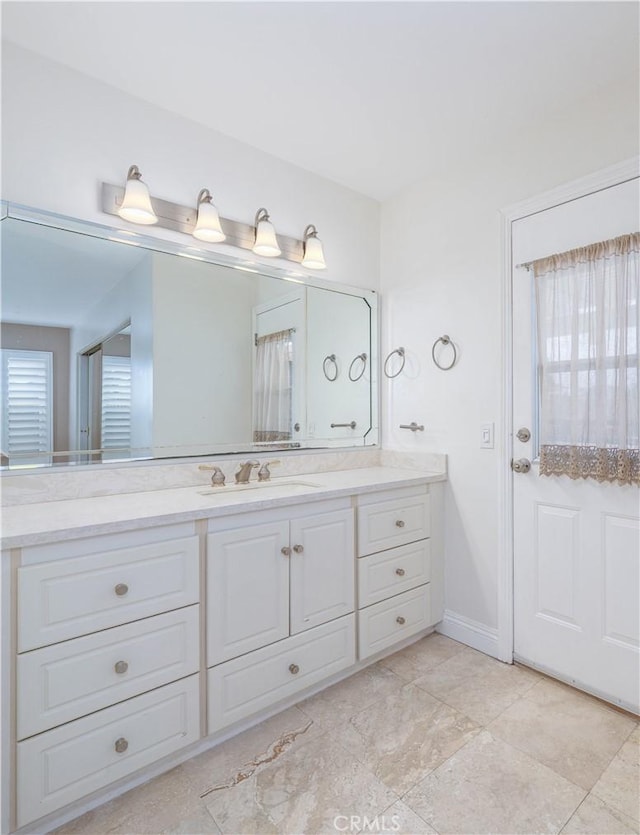 full bath with vanity and baseboards