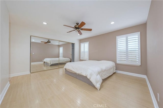 bedroom featuring light wood-type flooring, baseboards, recessed lighting, ceiling fan, and a closet