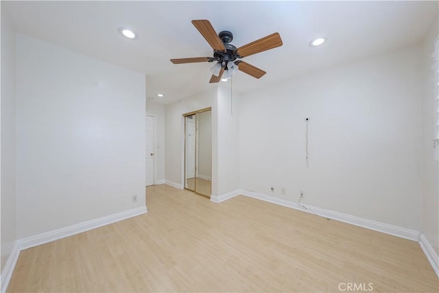 spare room featuring a ceiling fan, baseboards, light wood-style flooring, and recessed lighting