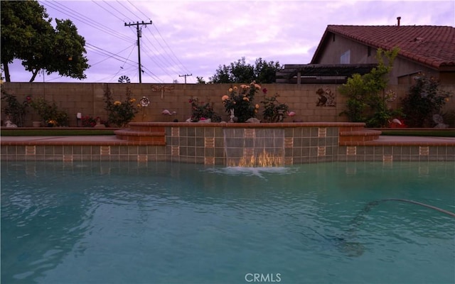 view of swimming pool with a fenced backyard