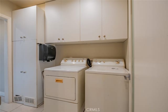 washroom featuring light tile patterned flooring, cabinet space, and washer and dryer