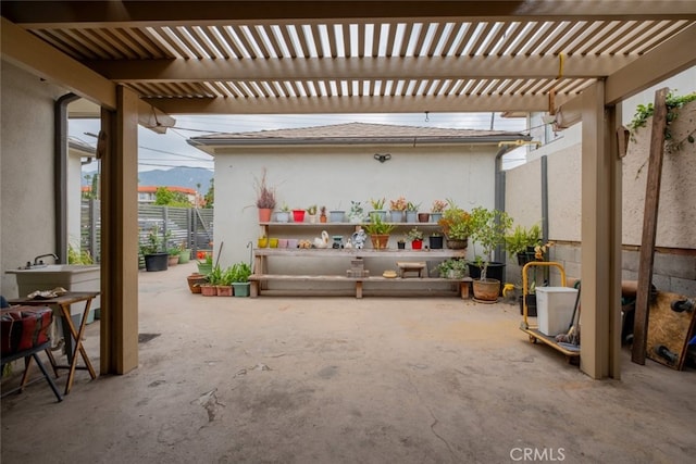 view of patio with fence, a pergola, and a mountain view