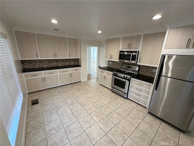 kitchen featuring crown molding, dark countertops, backsplash, light tile patterned floors, and stainless steel appliances