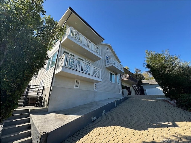 exterior space featuring stairs and a balcony
