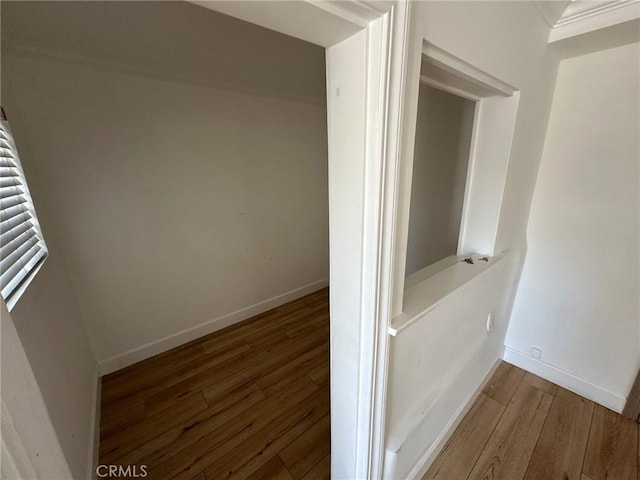 hall with baseboards and wood finished floors