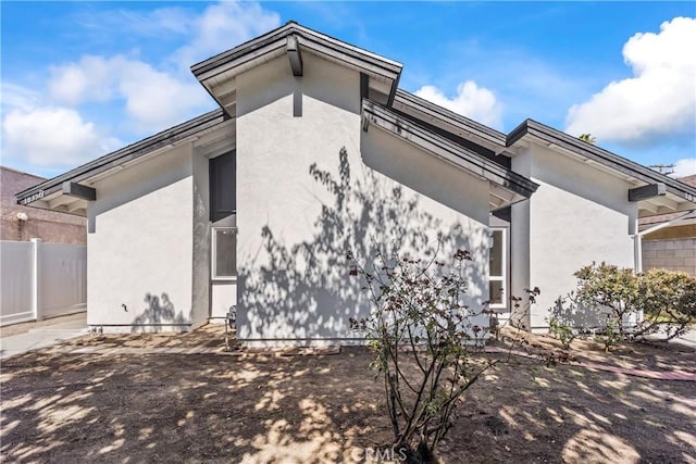 back of house with fence and stucco siding