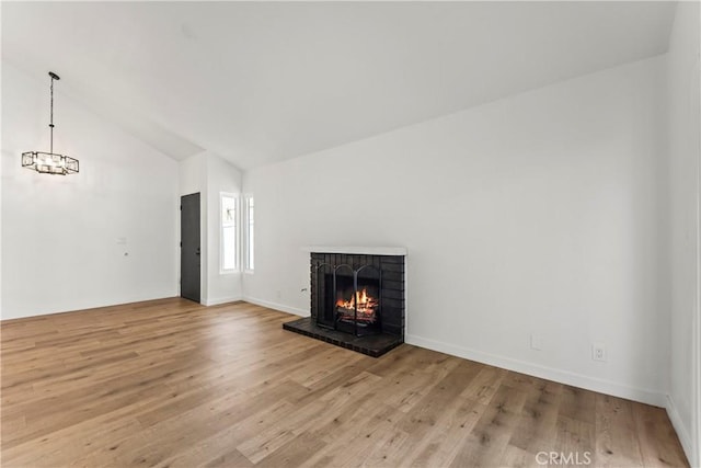 unfurnished living room featuring baseboards, a brick fireplace, high vaulted ceiling, and wood finished floors