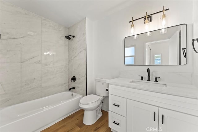 bathroom with vanity, toilet, wood finished floors, and bathtub / shower combination