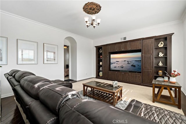 living room with visible vents, crown molding, arched walkways, baseboards, and an inviting chandelier
