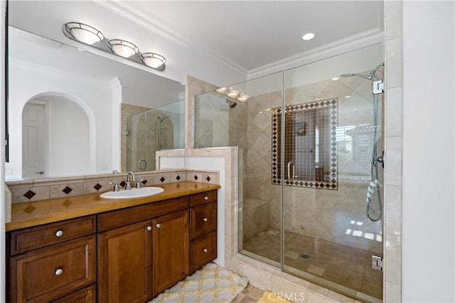 full bath with crown molding, vanity, and a shower stall