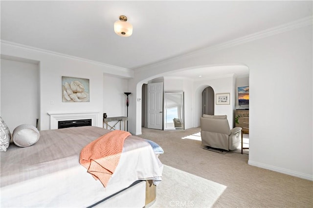 bedroom featuring baseboards, ornamental molding, arched walkways, and carpet flooring