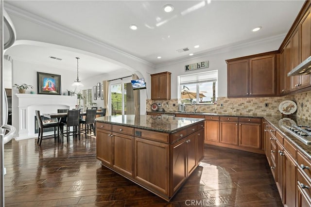 kitchen featuring visible vents, arched walkways, dark stone countertops, and dark wood-style floors
