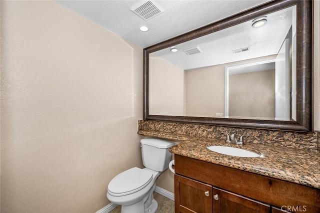 bathroom featuring baseboards, visible vents, toilet, and vanity