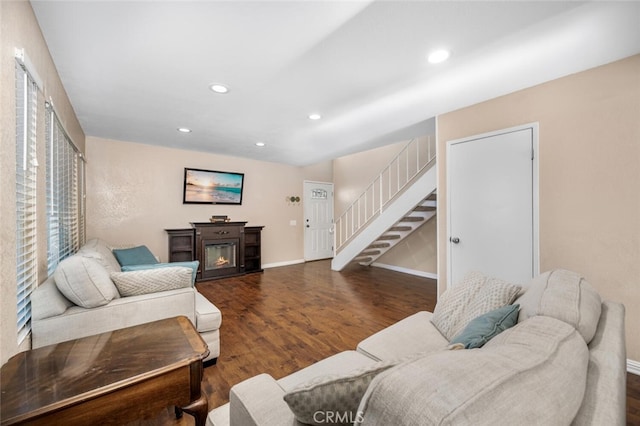 living room featuring recessed lighting, baseboards, wood finished floors, and stairway
